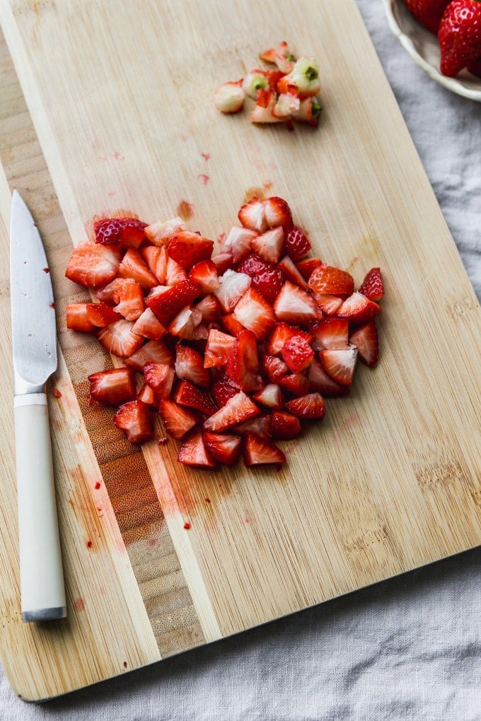 Diced strawberries on a cutting board.
