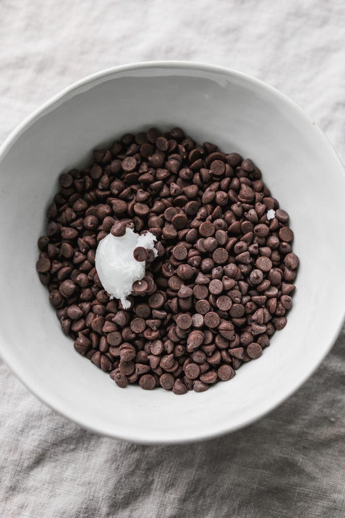 Chocolate chips with coconut oil in a small bowl.