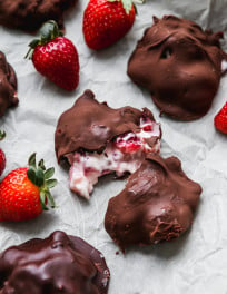 Chocolate covered strawberry yogurt clusters on parchment.