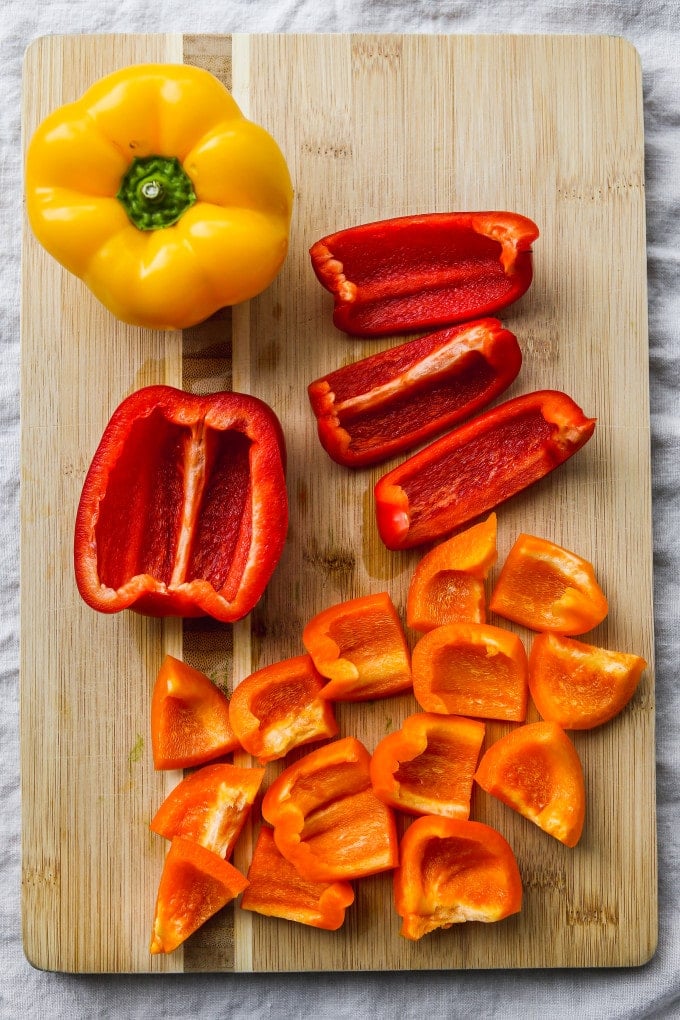 Bell peppers being cut into smaller pieces.