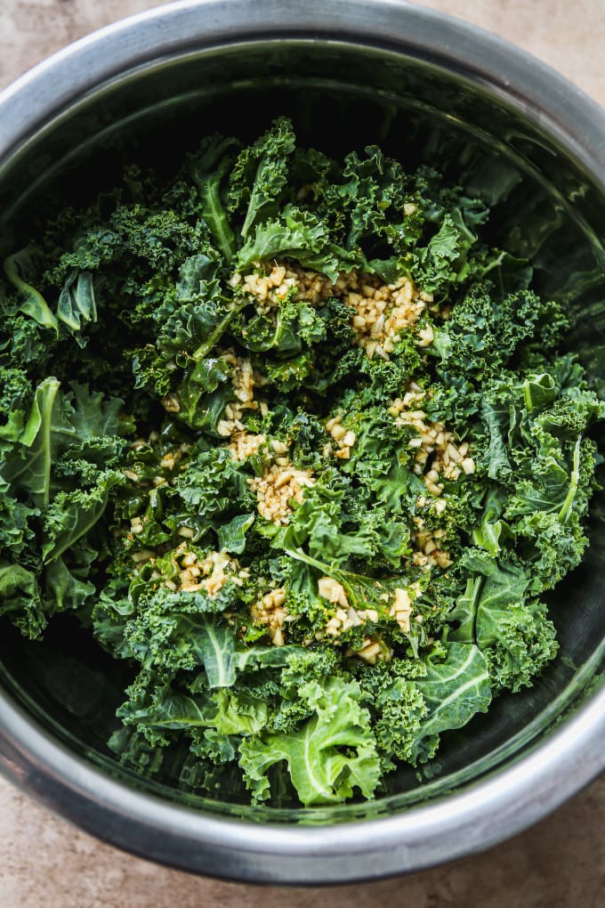 Torn kale leaves topped with dressing.