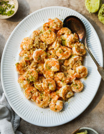 Ginger shrimp on a plate topped with lime zest.