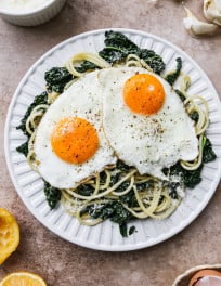 Kale lemon pasta topped with 2 fried eggs.