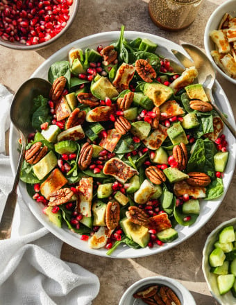 Spinach pomegranate salad on a large plate.