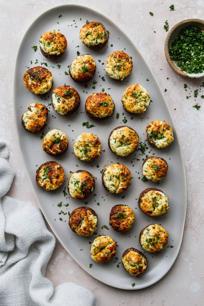 Goat cheese stuffed mushrooms appetizer on a serving tray.