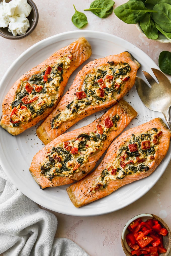 Spinach and feta stuffed salmon fillets on a white serving plate.